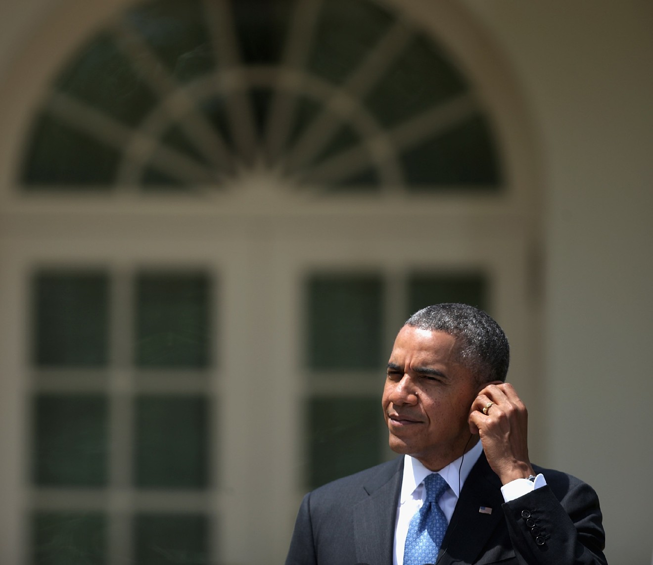 Former President Barack Obama pictured either talking to secret service or jamming some Leon Bridges.