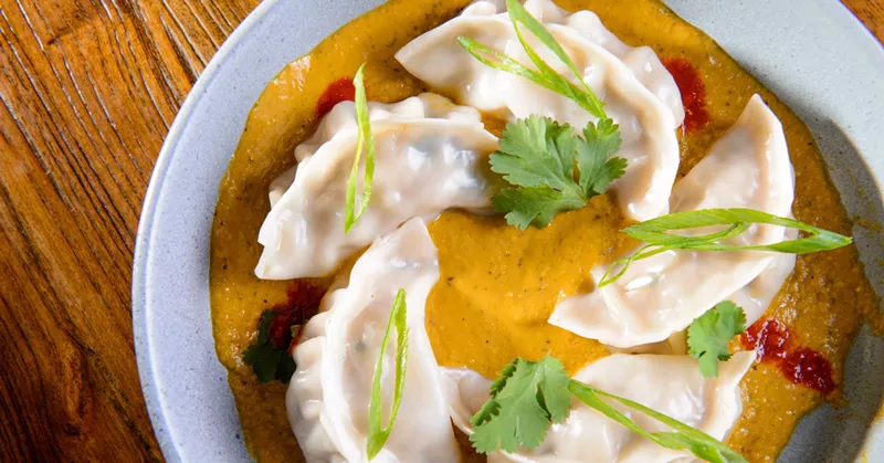 Image: Steamed Nepalese spice dumplings immersed in signature Bajeko Sekuwa Sauce