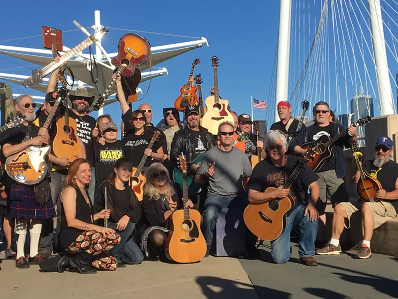 Image: All they are saying ... is give peace a chance? Barry Kooda (center, with green guitar) started the Open Carry Guitar Rally in 2014.