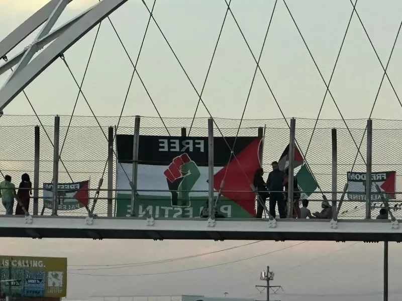 Image: Protesters have hung banners, signs and flags from the bridge during demonstrations.