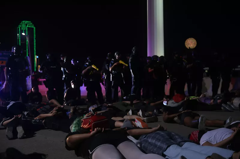 Image: Protesters lie on their stomachs waiting to be arrested by police after marching on the Margaret Hunt Hill Bridge June 1.