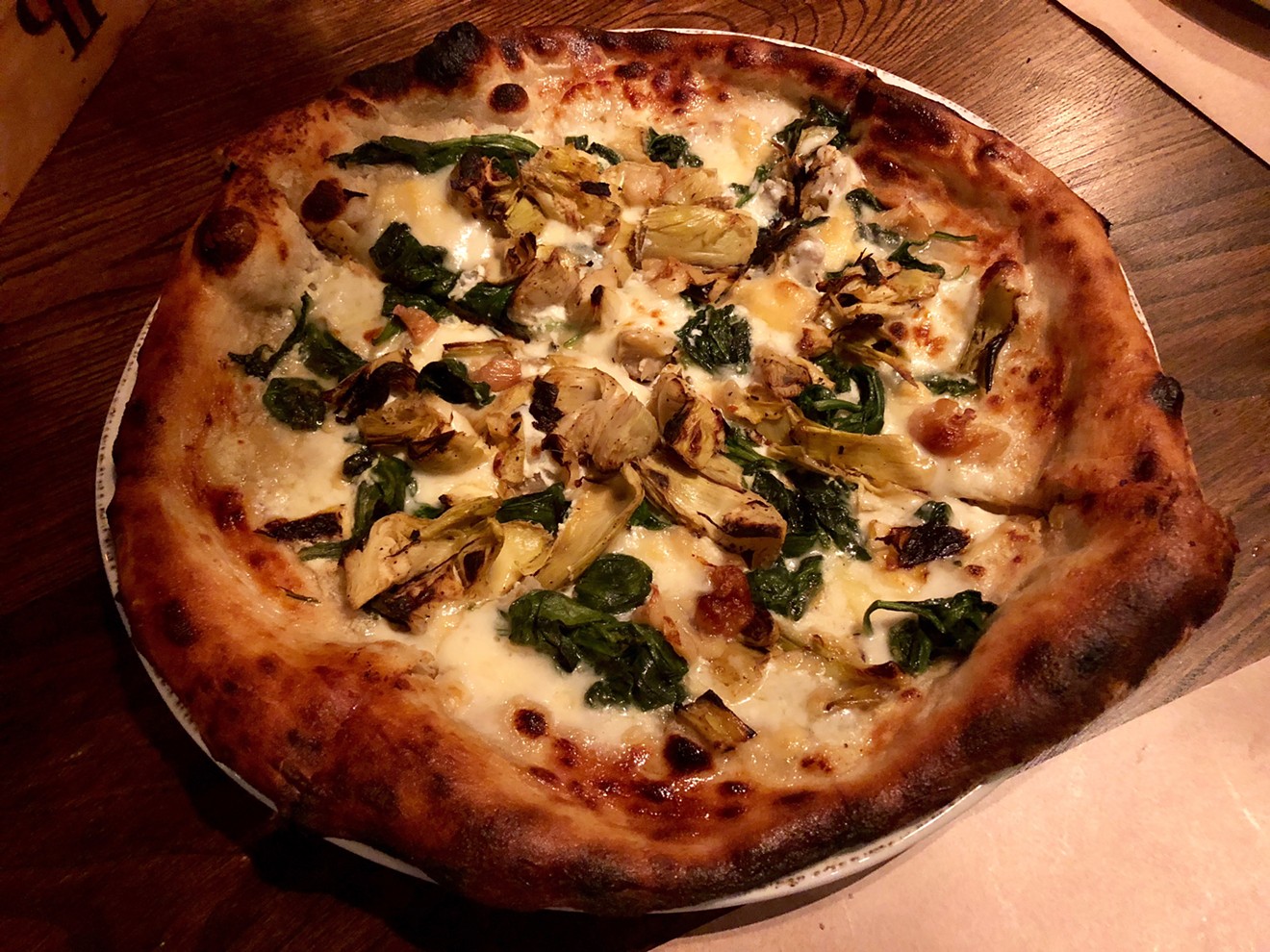 Peasant Pizzeria's Artichoke NYC ($16) is a white pizza rich with ricotta, fontina, mozzarella, charred artichoke, spinach and blistered garlic.