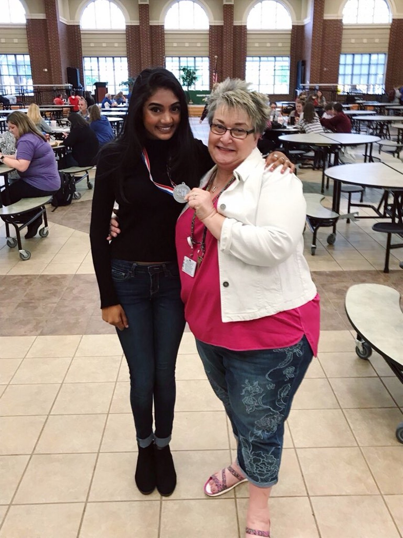 Prosper High School journalism instructor Lori Oglesbee-Petter shows off the University Interscholastic League regional competition medal won by Neha Madhira, a senior at Prosper High School and editor-in-chief of the Eagle Nation Online student news website.