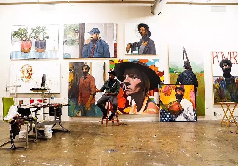 Image: Riley Holloway sits in front of his work.
