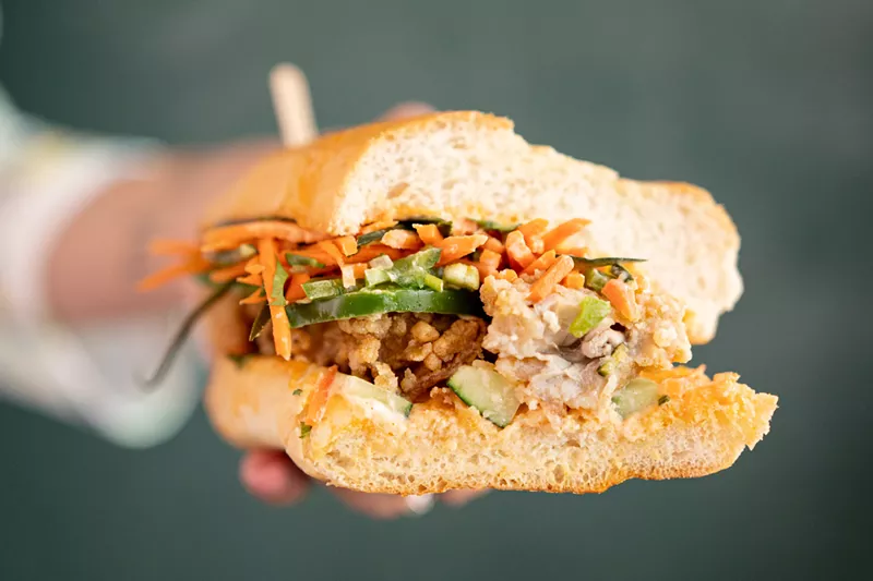 Image: The fried oyster bánh mì at Krio comes on a crusty yet soft loaf and overflows with carrots, jalapeños, cilantro and a spicy sauce.