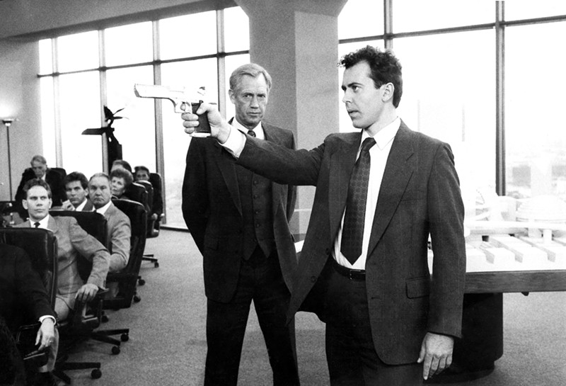 Actor Kevin Page, right, wields a gun at the faulty ED-209 commissioned by OCP executive Dick Jones, left, played by Ronnie Cox.