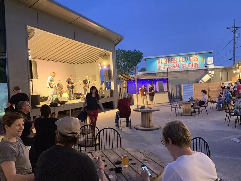 Image: A few people stand in the patio at Rubber Gloves in Denton watching a concert. The venue will no longer tolerate violent most pits.