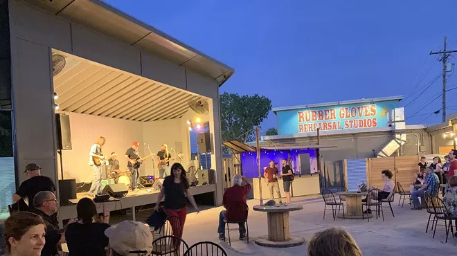 A few people stand in the patio at Rubber Gloves in Denton watching a concert. The venue will no longer tolerate violent most pits.
