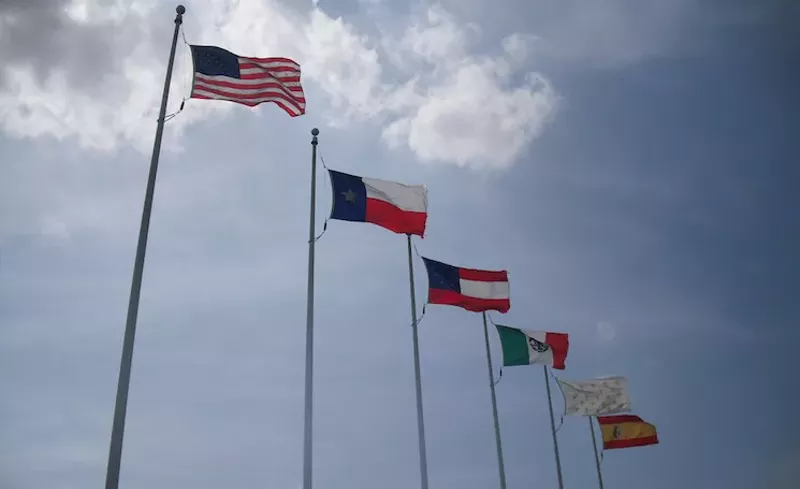 Image: The Stars and Bars (third from left) has been removed from the entrance at Six Flags Over Texas.