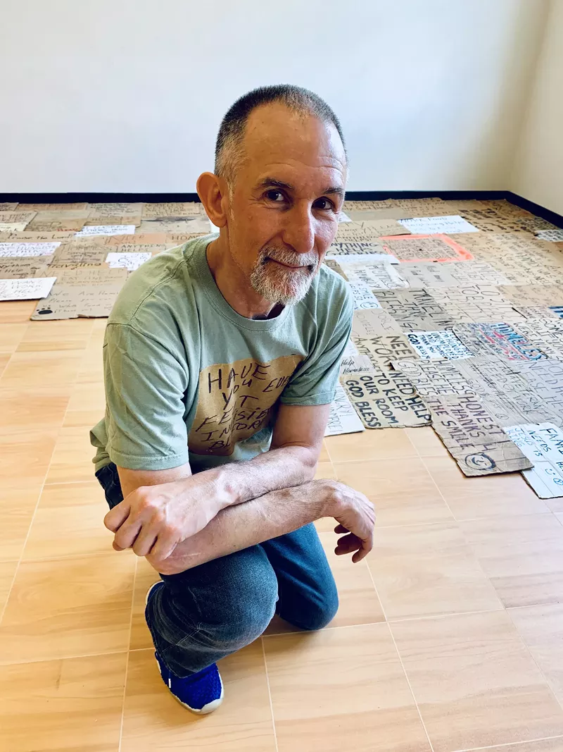 Image: Professor Willie Baronet with the collection of stories and memories he's amassed by buying signs from the homeless.