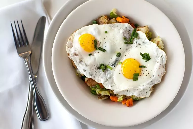 Image: Lucky's garden hash comes with two sunny side up eggs set in roasted seasonal vegetables and Brazos Valley cheddar.