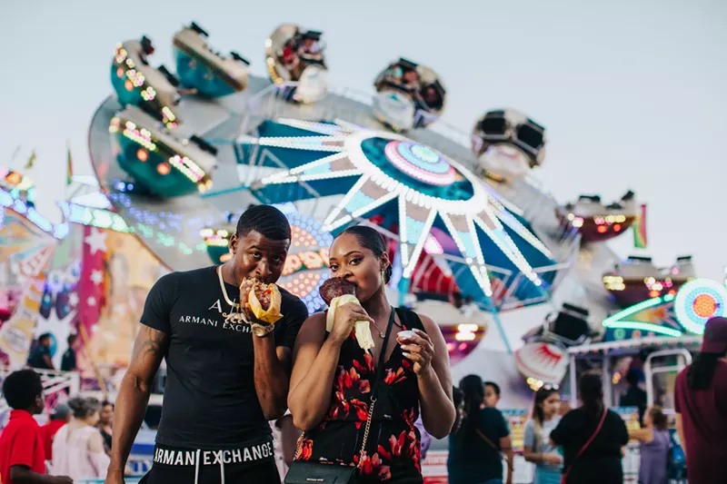 Image: two people eating at the state fair.