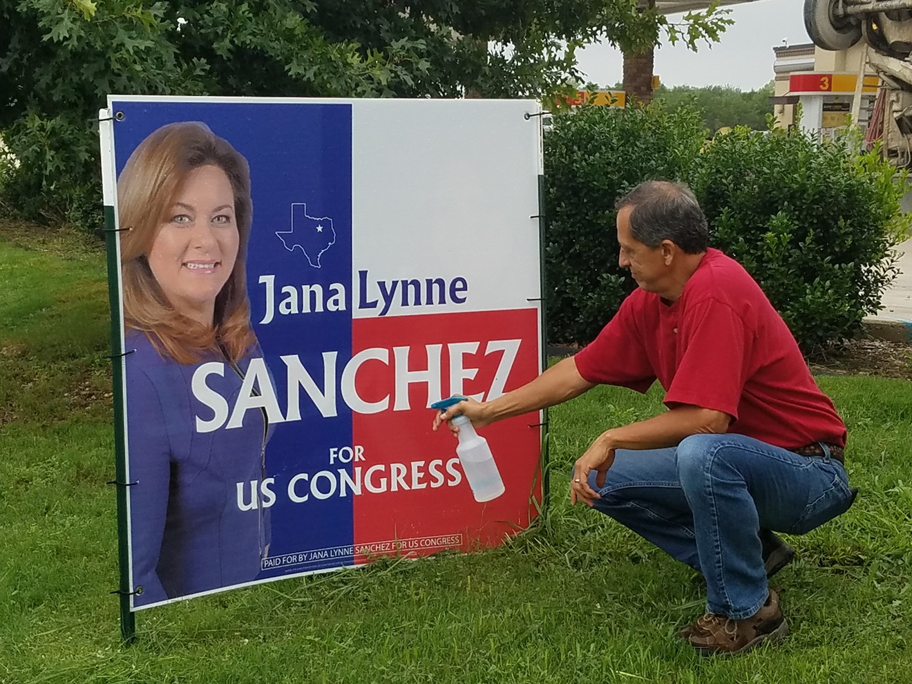 Anthony Arredondo, retired Dallas firefighter and volunteer for Sanchez's campaign, spraying skunk essence on one of the campaign signs.