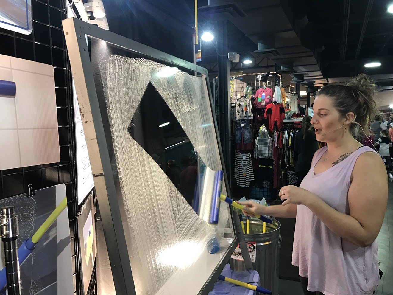 Alicia O’Connell stands in the male-dominated state fair showroom with her display of the Aquablade, a glorified squeegee whose makes says lasts for 10 years, leaving behind zero residue on windows for easy cleanup.