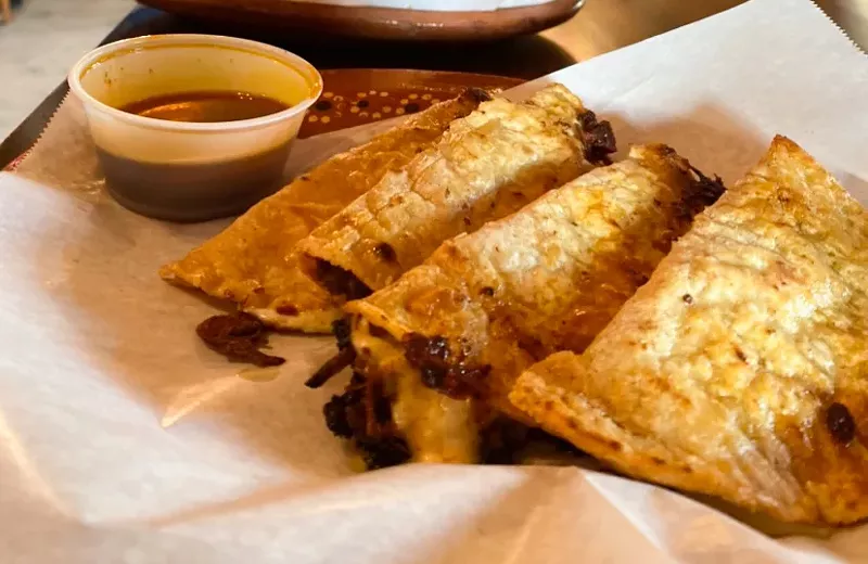 Image: A full order includes four birria tacos with consomé.