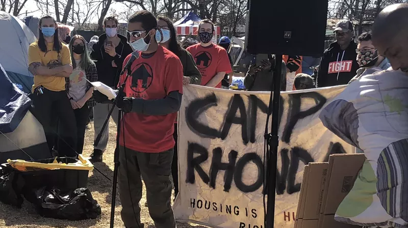 Image: Ryan Ahmadian, co-founder of the Dallas Houseless Committee and a member of Dallas Stops Evictions, reads a list of demands for the city of Dallas.