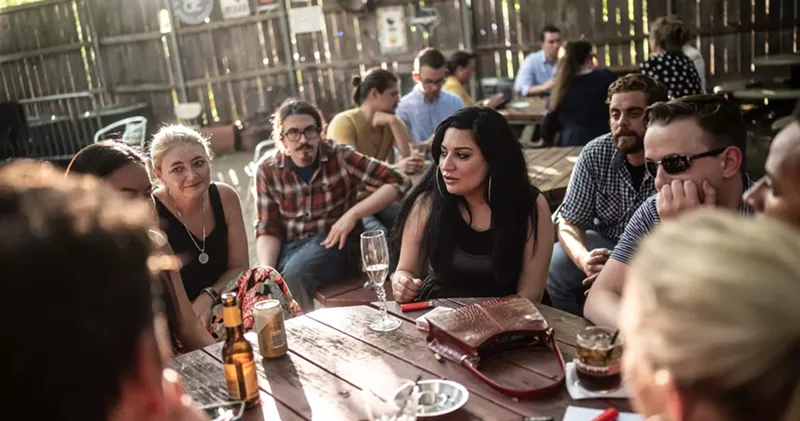 Image: Observer writers in a meeting, as photographer Mike Brooks said, "Where we go over priorities like how to ignore your band, how to play favorites, who to kiss up to and who to disrespect."