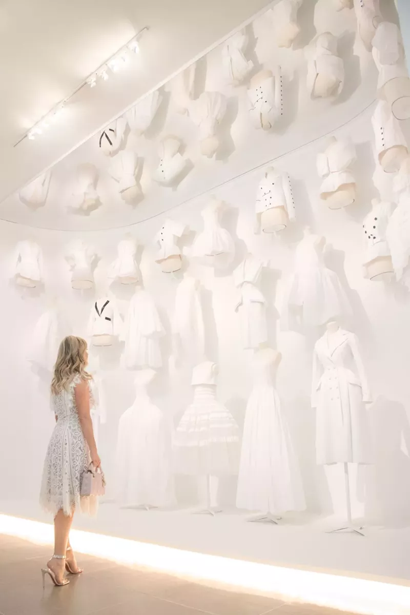 Image: A row of white garments in the dazzling Dior retrospective at the DMA