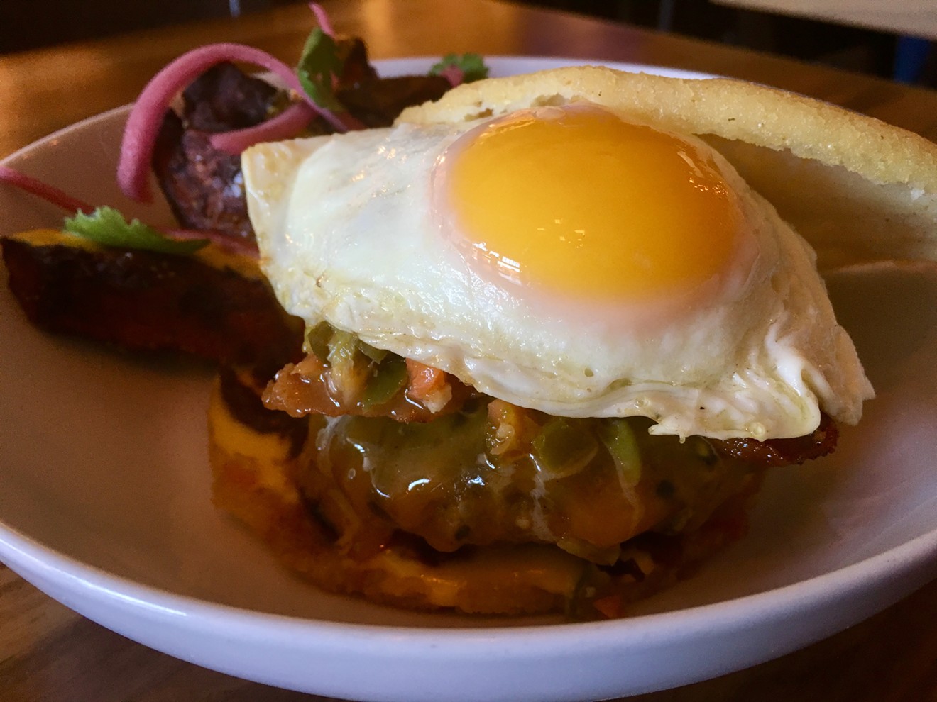 The arepa burger at Shoals in Deep Ellum, topped with a sunny egg for $7 at happy hour ($14 regularly).