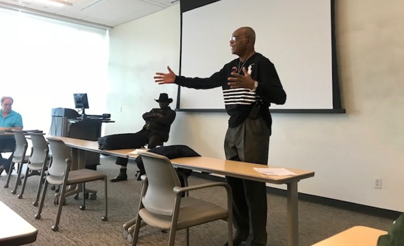 The Rev. Peter Johnson lectures to his UNT class while his cousin, blues musician Ernie Johnson, listens and mumbles affirmatively in the background.