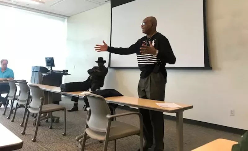 Image: The Rev. Peter Johnson lectures to his UNT class while his cousin, blues musician Ernie Johnson, listens and mumbles affirmatively in the background.