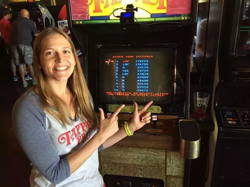 Image: Lauren Featherstone, a yoga and fitness teacher from Plano, achieved a record-breaking high score for the video game Tapper at Free Play Arlington.