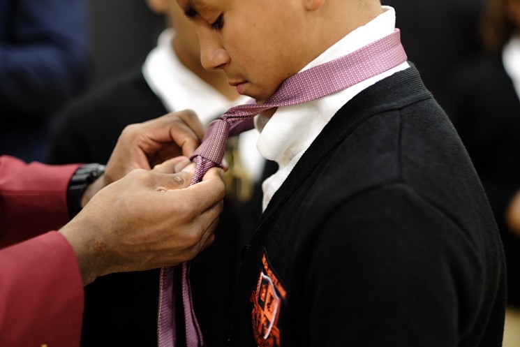 Alvin Johnson, a Lancaster police sergeant who was one of the 600 volunteers who showed up for the event, says some of the men brought ties for the students so they could show them how to tie them. - STEPHANIE DRENKA