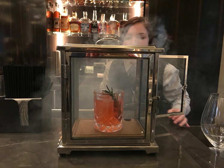 Beau Nash's Smoke and Rosemary ($16) is made with Avion silver tequila, Aperol and rosemary syrup, and it's briefly smoked with applewood chips. - BETH RANKIN