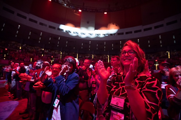 Audience members cheer during Trump's speech at the NRA convention in Dallas. - BRIAN MASCHINO