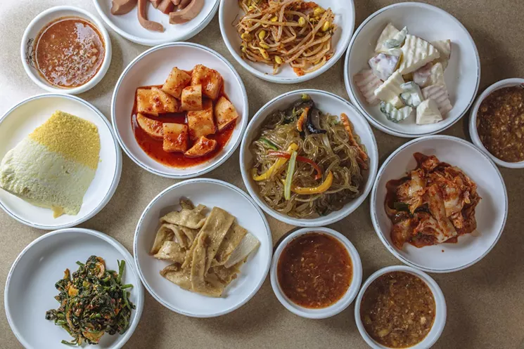 Jap chae — a bowl of glass noodles mixed up with scallions, shiitakes, sesame seeds and an assortment of vegetables — surrounded by banchan dishes at Dal Dong Nae in Dallas' Korea Town. - KATHY TRAN