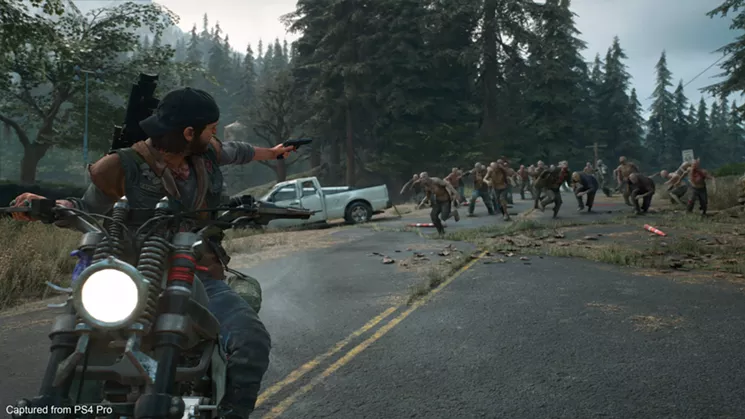 Deacon tries to outrun and outgun a horde of rampaging freakers in the post-apocalyptic, open-world adventure game Days Gone. - SONY INTERACTIVE/BEND STUDIO