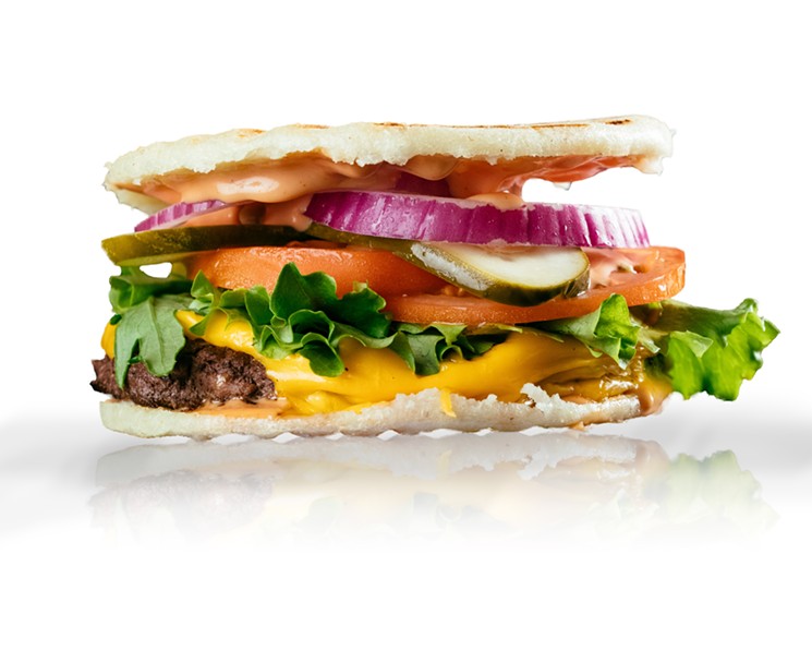 The cheeseburger at ArepaTX is served on an arepa instead of a classic bun. - KATHY TRAN