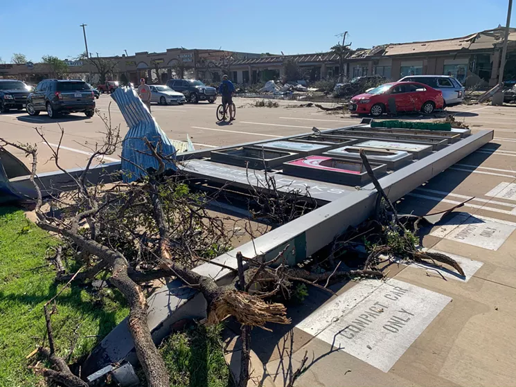 A sign for the shopping center on the southeast corner of Preston Road and Royal Lane lays flat from Sunday's tornado. In this same corner are dramatically damaged businesses, including Fish City Grill. - TAYLOR ADAMS