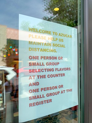 Rules to prevent the spread of the coronavirus are listed outside the shop's storefront. - TAYLOR ADAMS