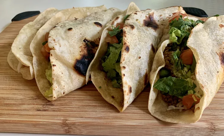 Tacos in roti, blistered flatbread, on the right are Keema Minced Beef with romaine lettuce, tomatoes and a creamy sauce. Shrimp tacos on the left in a spicier, coconut-based sauce. - NICK RALLO