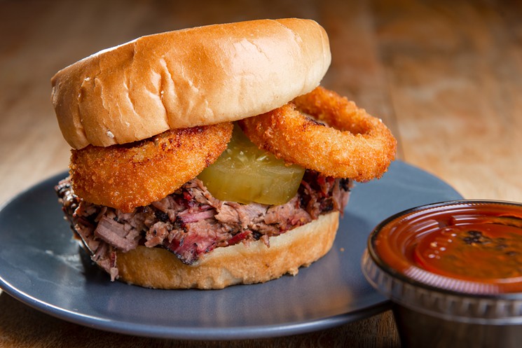 The GF sandwich: Chopped brisket, onion rings, sweet and spicy house-made pickles on a brioche bun, served with barbecue sauce - ALISON MCLEAN