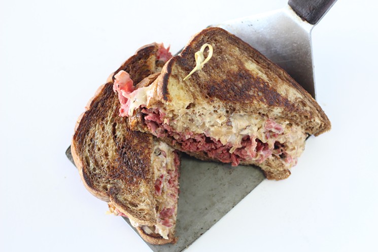 The corned beef Rueben is made with a housemade bacon-caraway sauerkraut smothered with Colossal Sauce and melted Swiss cheese on buttered marble rye. - COURTESY OF COLOSSAL SANDWICH SHOP
