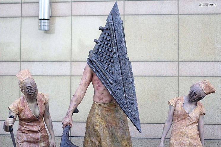This is a cosplayer dressed up as Pyramid Head from Silent Hill, with friends. - JOHNSON WEN, CC BY-SA 2.0, VIA WIKIMEDIA COMMONS