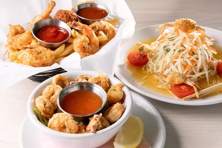 A shredded papaya salad adorned with fried crab alongside a seafood basket and calamari made with Krio's rice flour batter. - ALISON MCLEAN