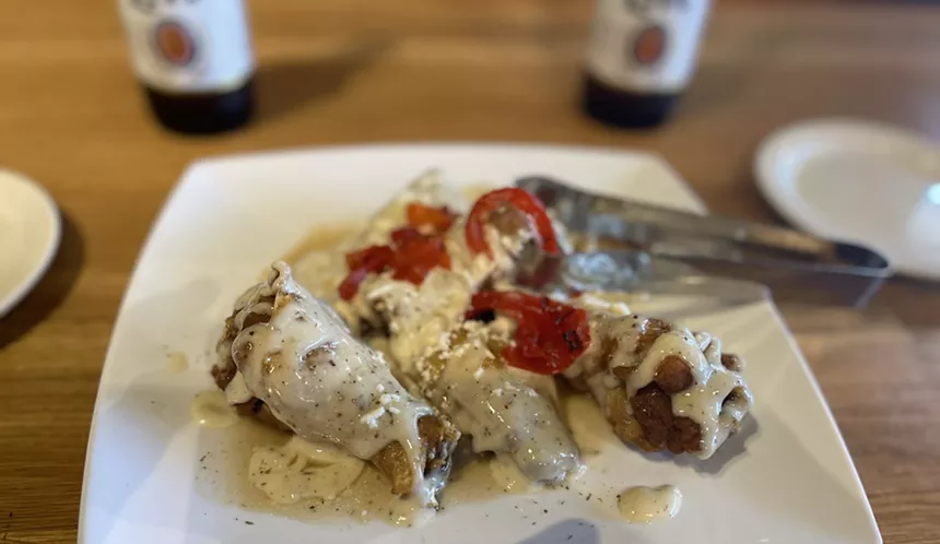 The wings are seasoned with Greek oregano, covered with a garlic-feta sauce and topped with roasted red bell peppers. - ANGIE QUEBEDEAUX