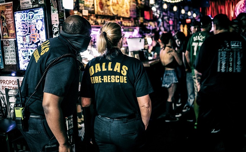 Dallas Fire and Rescue officers look into Three Links in Deep Ellum to make sure it’s not over capacity. The show’s promoter had to get on stage and ask that 14 people leave the bar and go stand on the sidewalk. - MIKE BROOKS