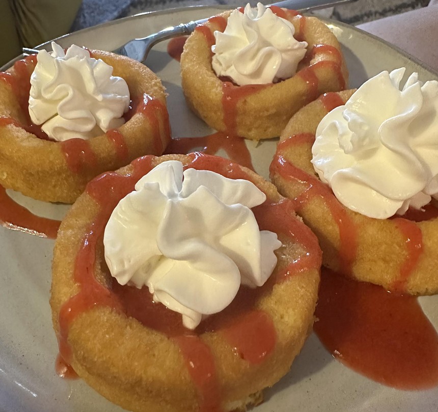 A plate of miniature stawberry shortcakes topped with whipped cream.
