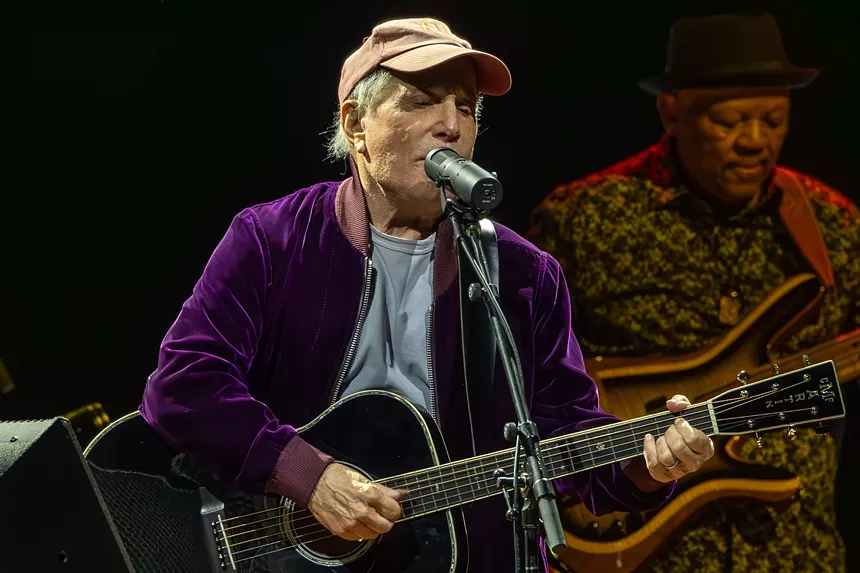 Man performing on stage with a guitar
