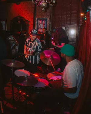 A group of band members playing in front of an audience
