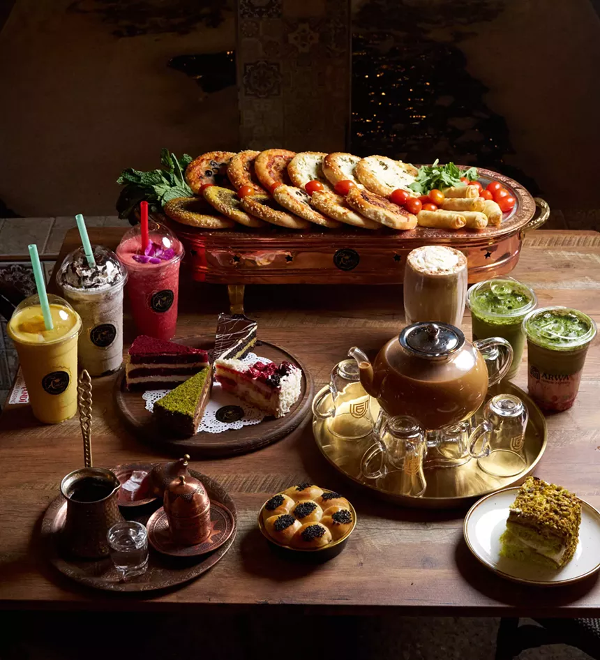 A mix of dishes from Arwa Yemeni Cafe (iced drinks, coffee, pistachio cake, and honeycomb bread) and Aladdin Cafe (smoothies, cake slices, coffee).