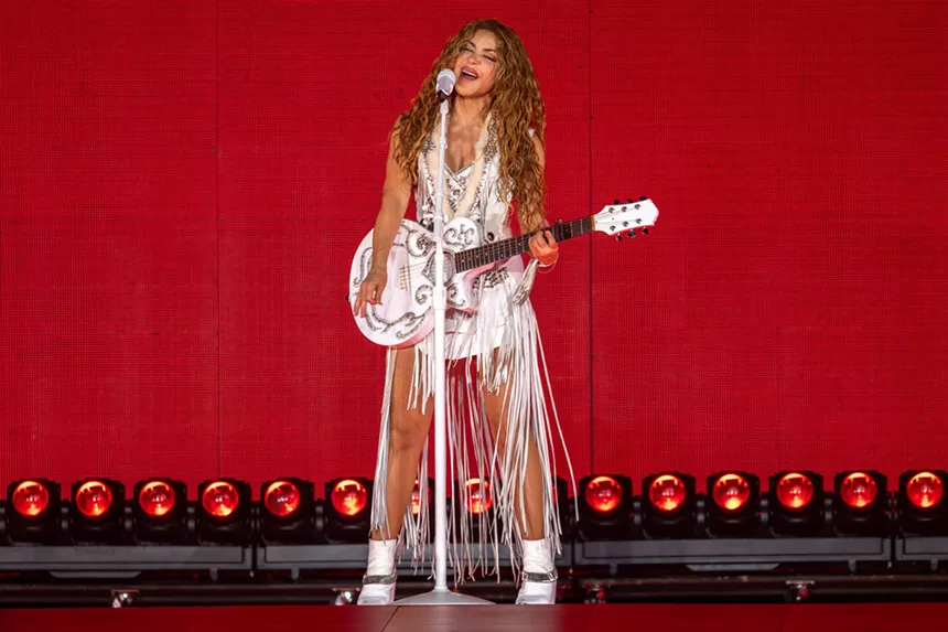 Woman performing on stage with a guitar