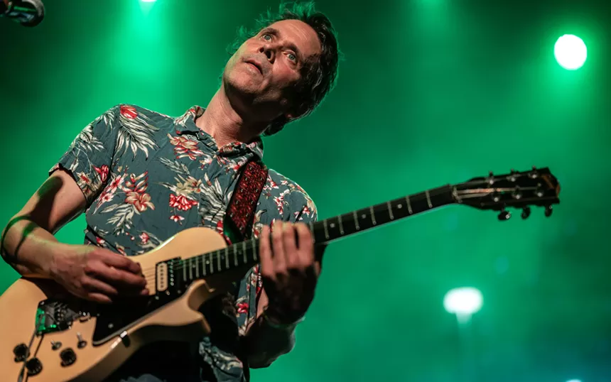 A man performing on a guitar