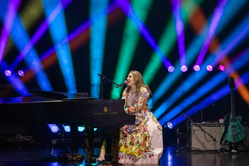 A woman singing on a piano