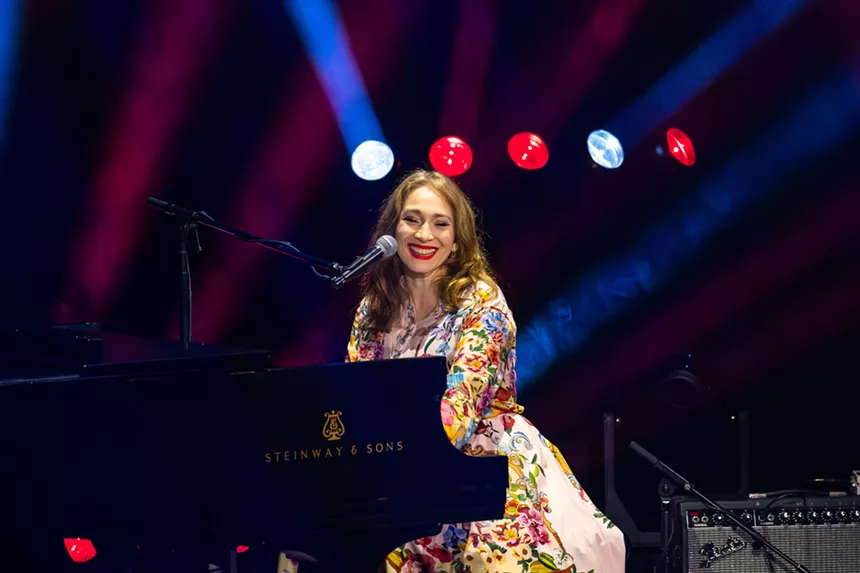 A woman singing on a piano