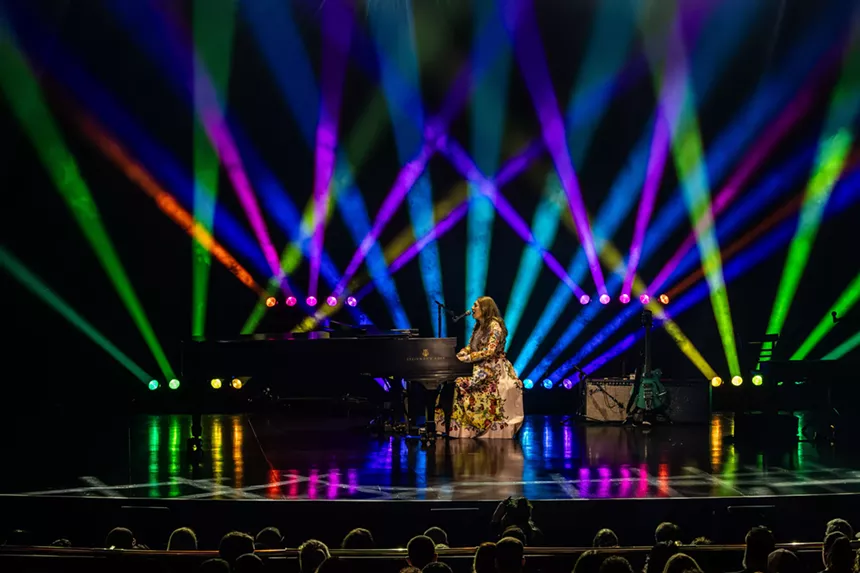 A woman singing on a piano